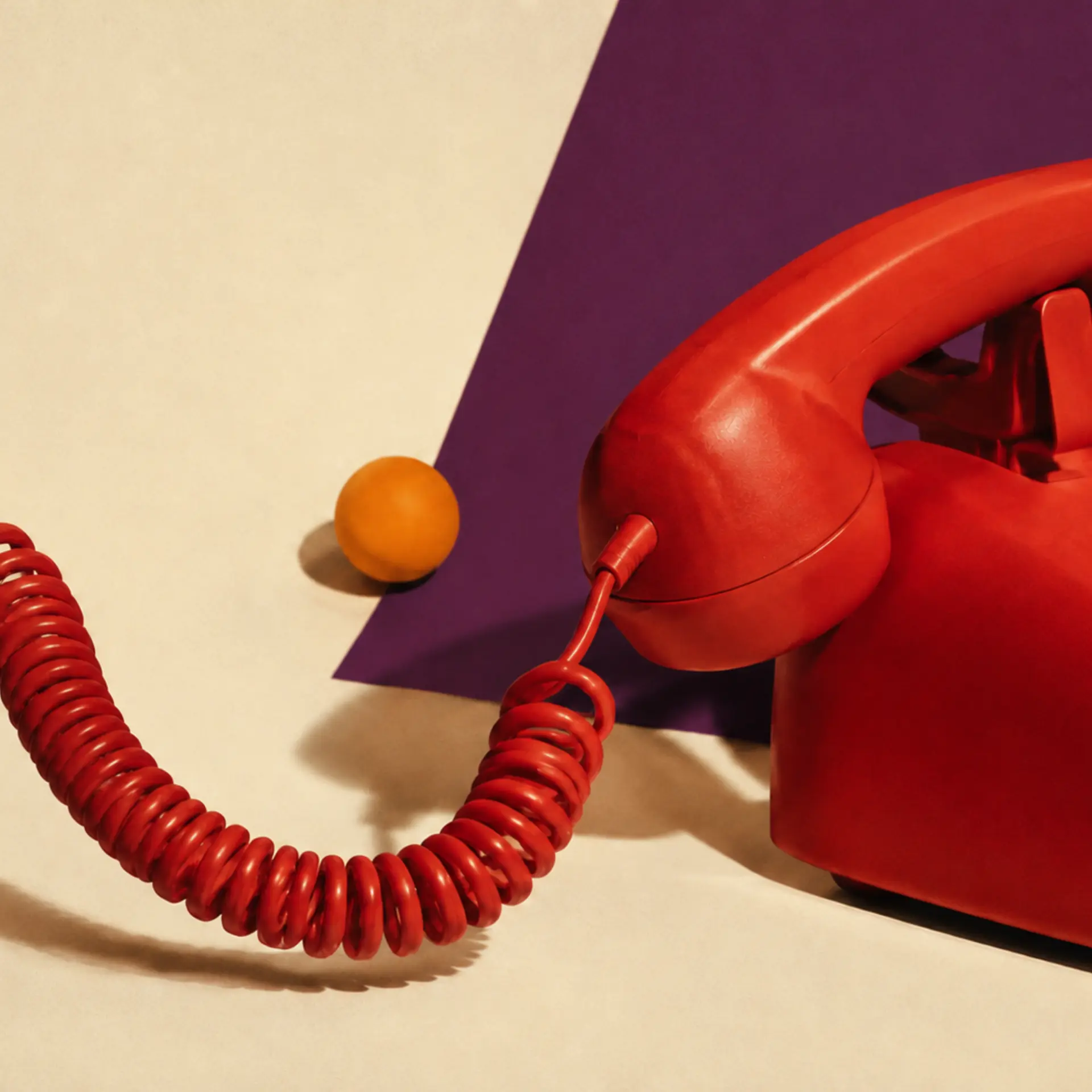 Vintage red telephone on a cream surface, RSVP Online Talent